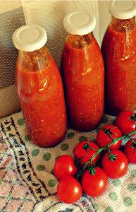 Eingekochte Tomaten in Gläser abfüllen